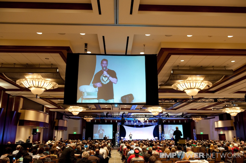 Packed hotel ballroom watching a speaker on the jumbo screen at Empower Network's 2012 Atlanta event