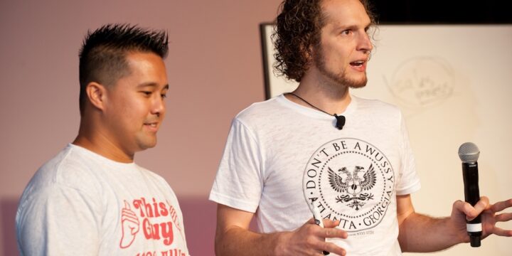 Two presenters teaching side by side in front of a whiteboard at Empower Network's 2012 Atlanta event