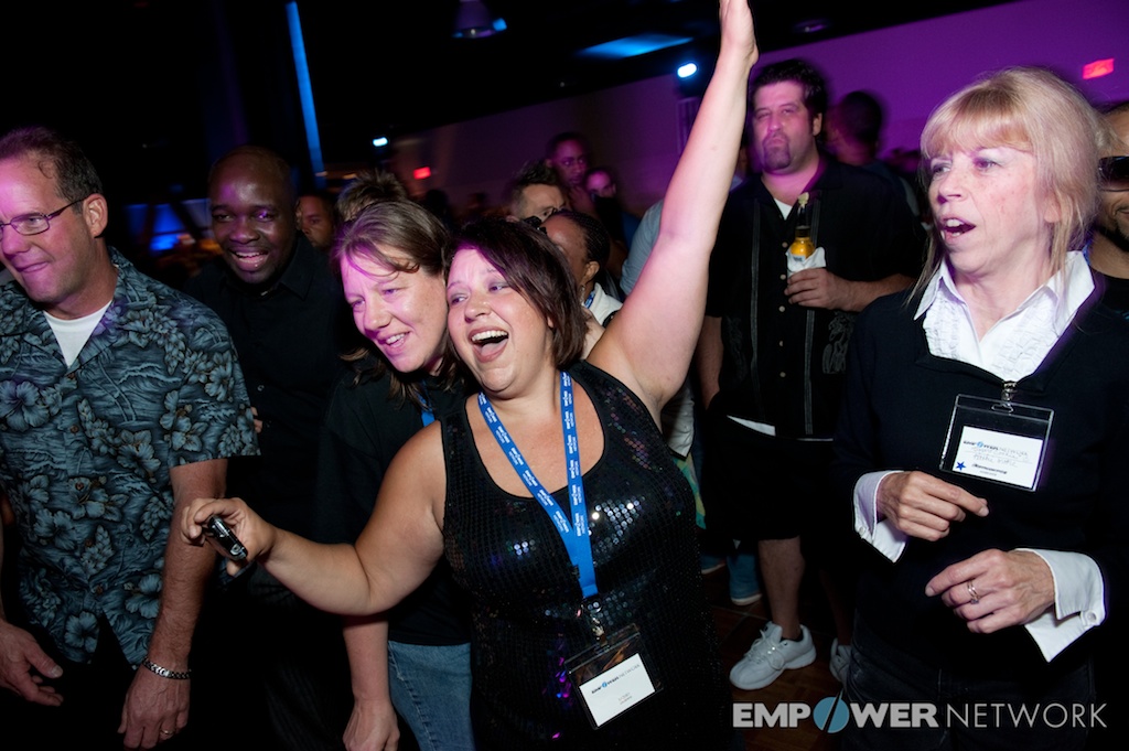 Attendee celebrating with one arm raised high on the dance floor at Empower Network's 2012 Atlanta event