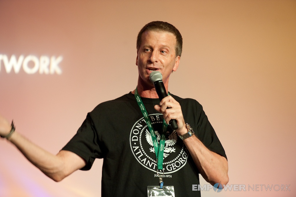 Speaker in event t-shirt gesturing while addressing the room at Empower Network's 2012 Atlanta event