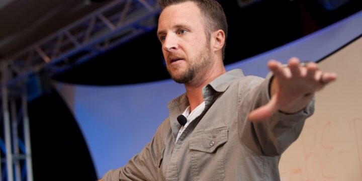 Speaker reaching out toward the audience while teaching on stage at Empower Network's 2012 Atlanta event