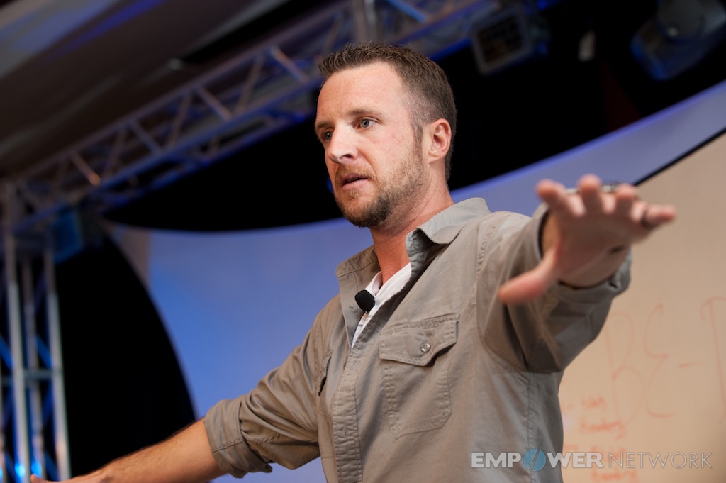 Speaker reaching out toward the audience while teaching on stage at Empower Network's 2012 Atlanta event