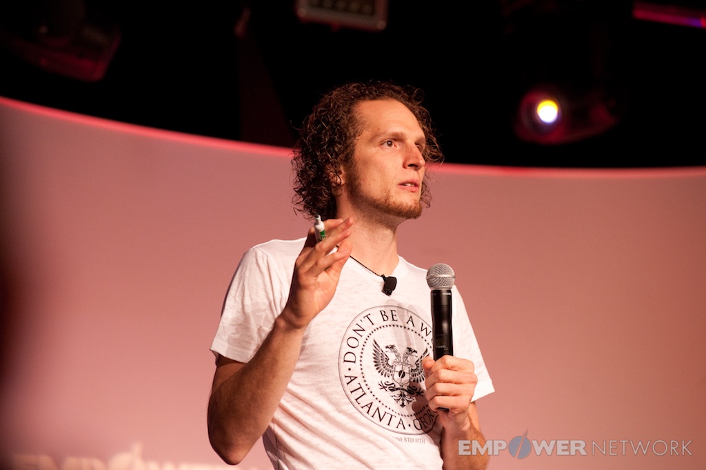 Speaker gesturing thoughtfully while explaining a concept on stage at Empower Network's 2012 Atlanta event
