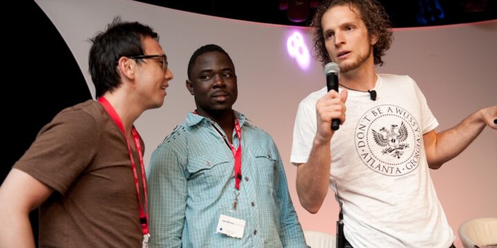 Presenter with microphone coaching two attendees on stage at Empower Network's 2012 Atlanta event