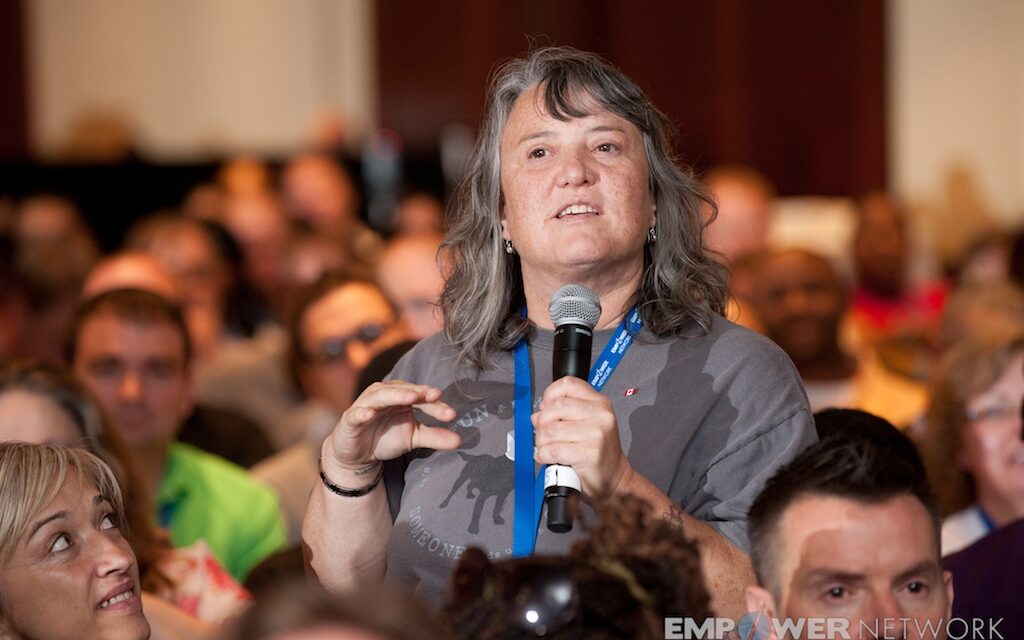 Attendee standing in the audience sharing into a microphone at Empower Network's 2012 Atlanta event