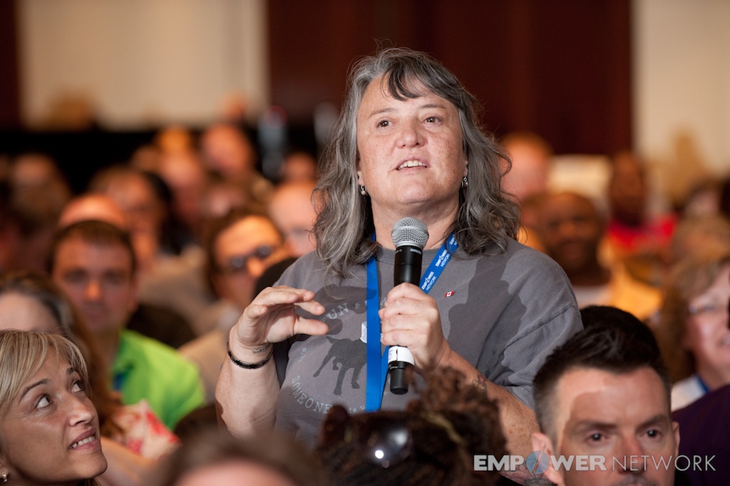 Attendee standing in the audience sharing into a microphone at Empower Network's 2012 Atlanta event