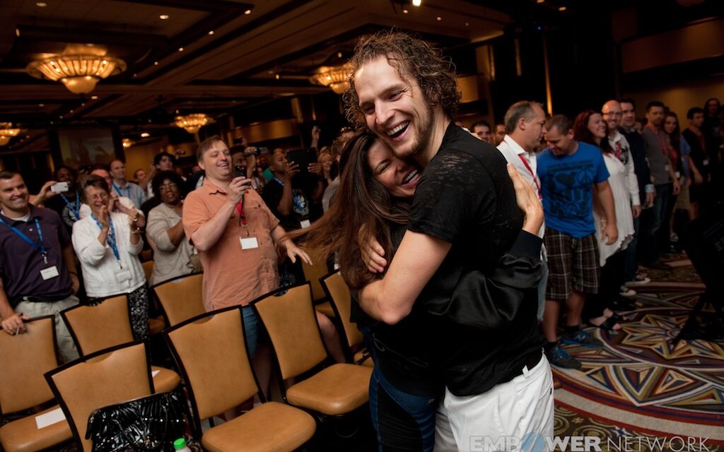 Speaker hugging an attendee as the surrounding crowd applauds at Empower Network's 2012 Atlanta event