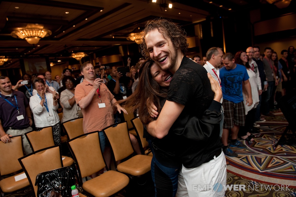Speaker hugging an attendee as the surrounding crowd applauds at Empower Network's 2012 Atlanta event